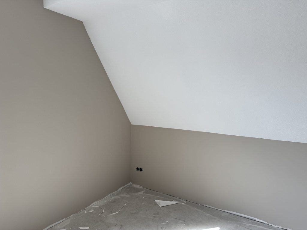 Zolderkamer in een nieuwbouwwoning met een schuine wand en afgewerkte wanden in twee tinten